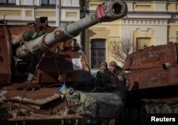 یوکرینی فوجی کیف میں روس کے ایک تباہ شدہ ٹینک کی نمائش کر رہے ہیں۔ 27 فروری 2024