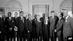 اس 28 اگست 1963 کےفائل فوٹومیں، صدر جان ایف کینیڈی وائٹ ہاؤس میں مارٹن لوتھر کنگ جونیئر سمیت سیاہ فام رہنماؤں کے ایک گروپ کے ساتھ کھڑے ہیں۔ فوٹو اے پی