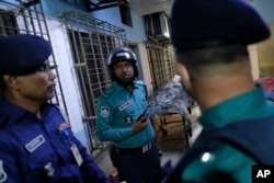 ڈھاکہ میں ٹرین نذر آتش کیے جانے کے دوران ہلاک ہونے والے لوگوں کی نعشوں کے ساتھ سیکیورٹی آفیسرزکھڑے ہیں، فوٹواےپی 19 دسمبر 2023