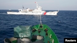 Tàu hải cảnh Trung Quốc (trên) và tàu Cảnh sát biển Việt Nam trong vụ đụng độ vào tháng 5 năm 2014 khi Trung Quốc kéo giàn khoan Hải Dương 981 vào khu vực gần quần đảo Hoàng Sa, nơi cả hai nước đều tuyên bố chủ quyền.