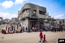 غزہ کے قصبے خان یونس میں فلسطینی خوراک کی تقسیم شروع ہونے کے انتظار میں ایک لمبی قطار میں کھڑے ہیں۔ 14 مئی 2024