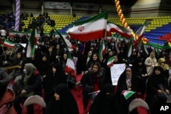 انتخابی مہم کے دوران خواتین ایرانی پرچم لہر رہی ہیں۔ ہکم مارچ کو ہونے والے انتخابات کی 290 نشستوں کے لیے 15 ہزار امیدوار میدان میں ہیں۔ 28 فروری 2024