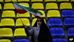 تہران میں ایک خاتون ایران کا جھنڈا لہرا رہی ہے، 28 فروری 2024